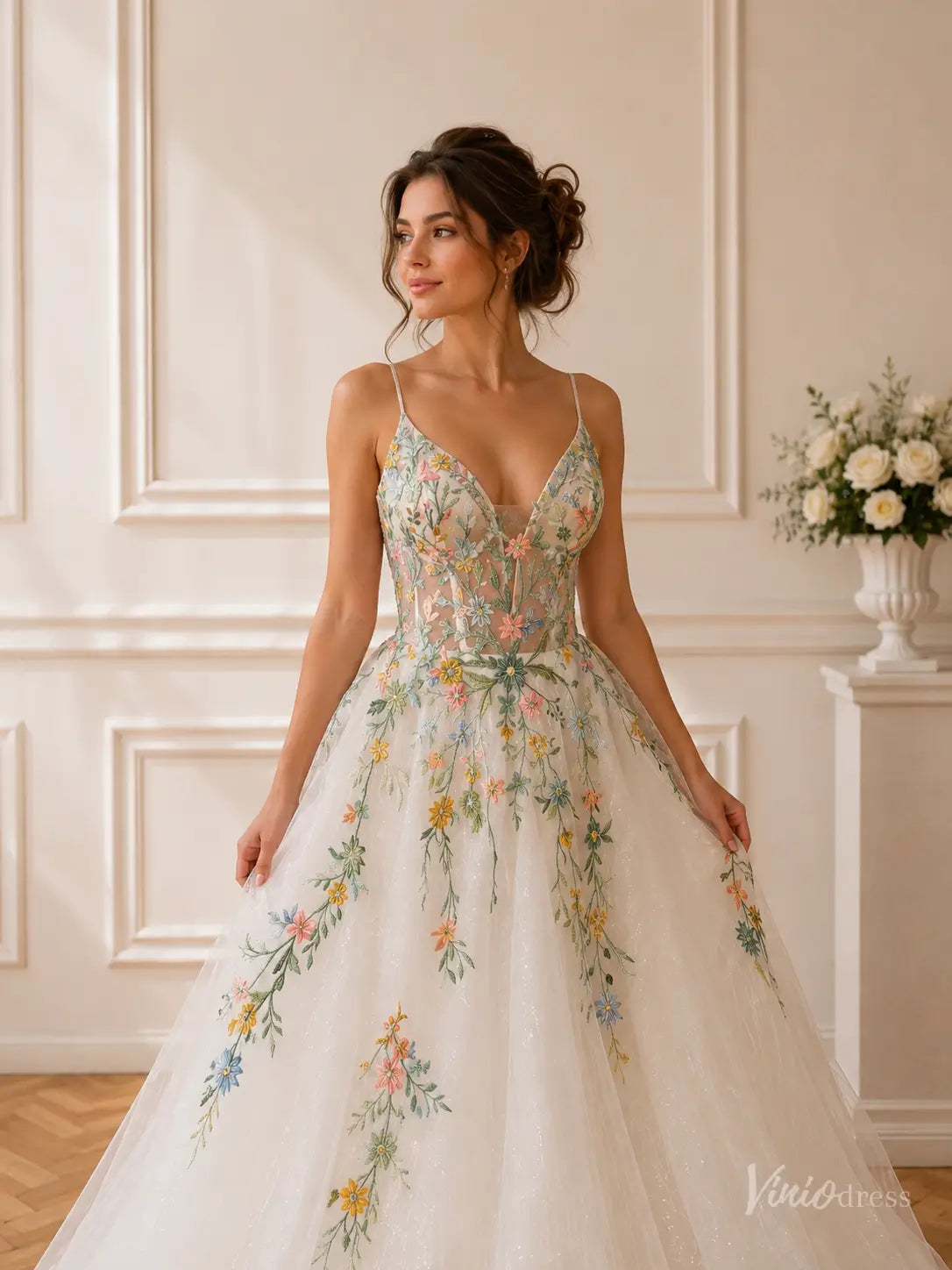 Whimsical wedding dress with spaghetti straps, floral embroidery, and a sparkling glitter tulle skirt.