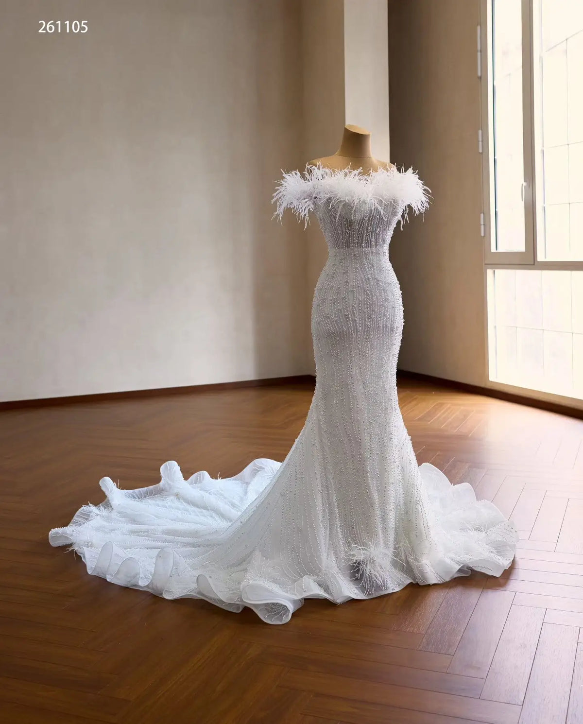 White mermaid wedding dress with feather off-shoulder neckline, vertical pearl beading, and ruffled flared hem.