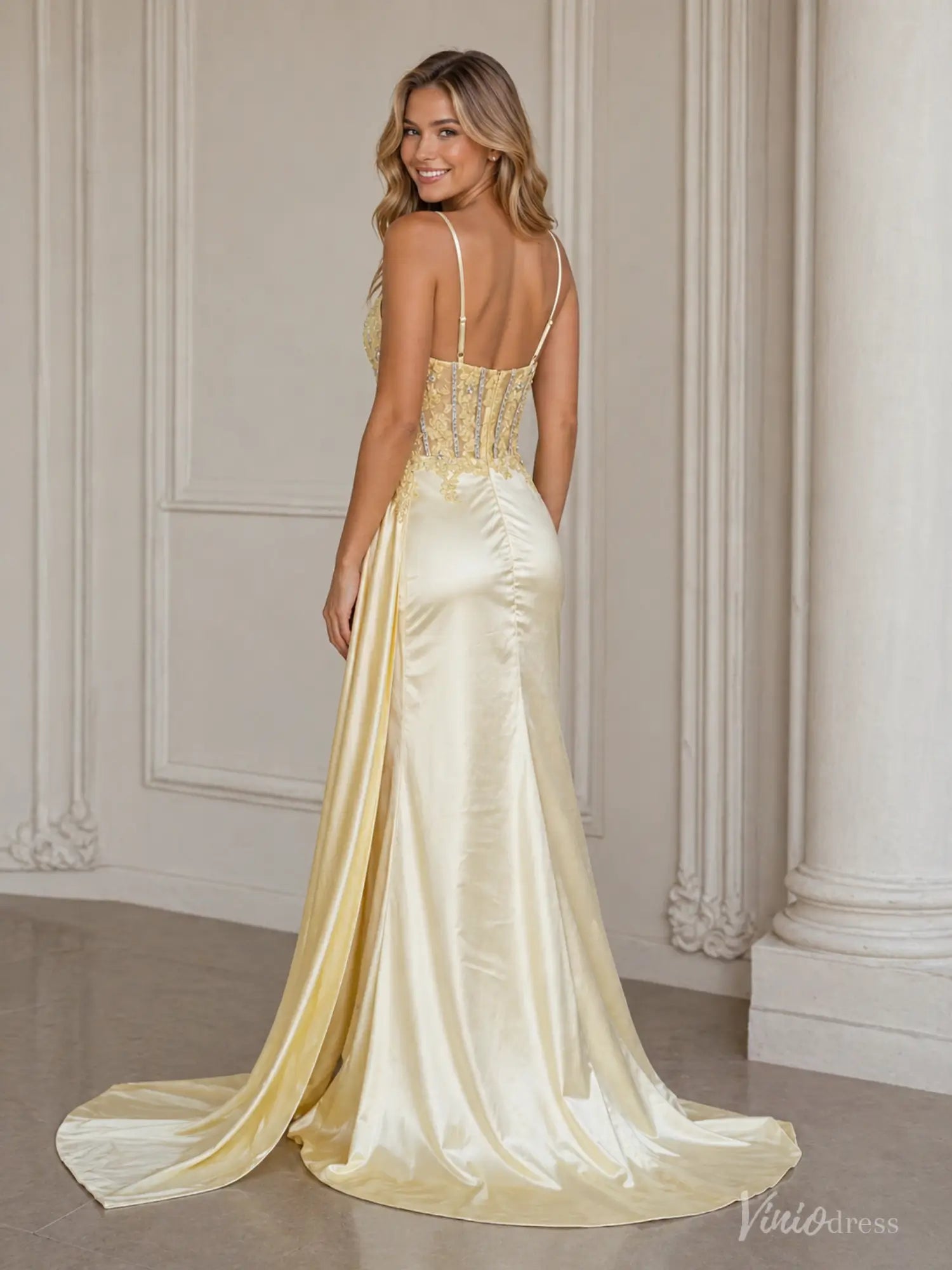 Yellow satin prom dress with a beaded corset bodice, spaghetti straps, and a flowing skirt with a side sash.