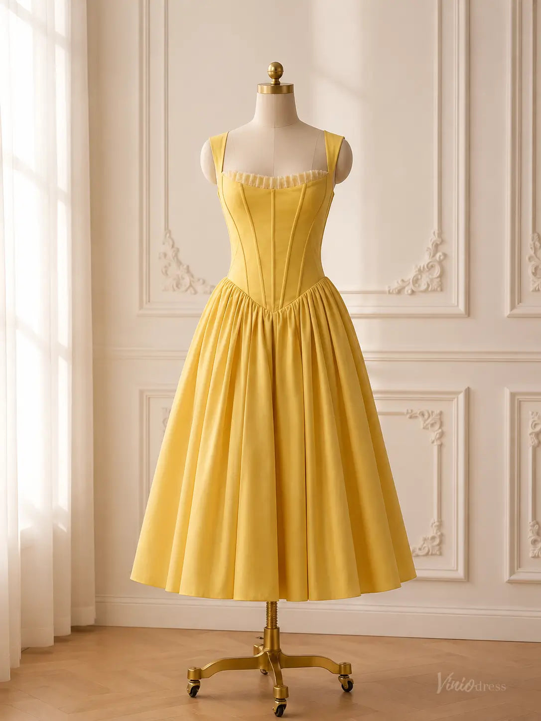 Yellow satin tea-length prom dress with a corset bodice, ruffle-trimmed square neckline, and Basque waist on a mannequin.